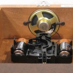 In the model 70687-N92215, the speaker is mounted to an opening in the top of the case. The the top board acts as a baffle for the speaker, allowing good volume and clear, rich sound.