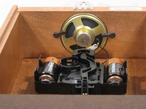 In the model 70687-N92215, the speaker is mounted to an opening in the top of the case. The the top board acts as a baffle for the speaker, allowing good volume and clear, rich sound.