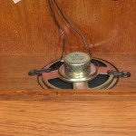 In the model 22825-i92115, the speaker is mounted over an opening in the bottom of the case. The case bottom acts as a baffle for the speaker, creating a rich, full chime sound
