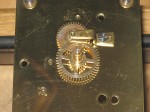 Old style motion work, with minute wheel mounted under a cock. Starting about 1950, the diameter of the cannon pinion was reduced and the minute wheel was mounted with a screw through its center.